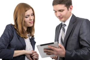 Two people looking at a tablet together.